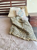 Throw blanket with leopard pattern draped on bed