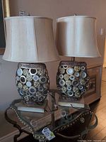 Pair of ornate table lamps on glass side table