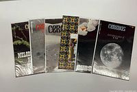 Six bagged Cerebus comics arranged side by side showing distinct covers