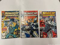 Front view of all three bagged RoboCop comic books issues 2, 8, 14