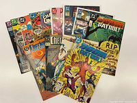 Group shot of 13 DC comics spread out, showing cover titles and issue numbers