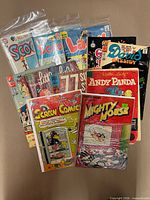 All 13 bagged comics fanned out showing variety of titles