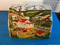 Front of tin tunnel showing lithographed mining scene