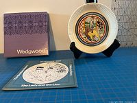 Front view of plate on stand with booklet and box