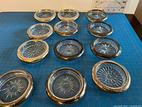 Top view showing all 12 glass coasters with silver-plated rims