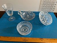 group of four crystal pieces including goblet, handled candy dish and two round dishes with ruler for scale