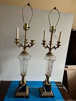 Full view of both lamps showing crystal columns, brass arms, marble bases