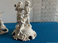 Front view of group-of-three cherub musician figurine on ornate base