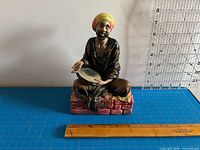 Front view of figurine showing overall appearance and scale with ruler