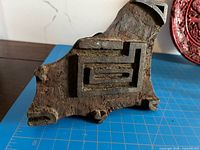 Front view showing carved geometric motif and surface wear