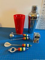 All items grouped: shaker, tumbler, four rainbow-handle tools, box of picks