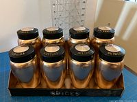 Front view of eight spice shakers seated in rack