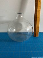 Full view of spherical Pyrex flask beside ruler showing size