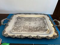top view of ornate Rogers Bros silver-plated tray showing border, handles and centre engraving