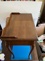 Top view of desk showing wood grain, raised back gallery and surface wear