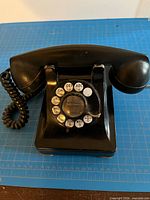 Front view of black Western Electric rotary telephone showing dial and handset
