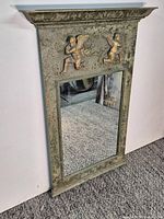 Full view of mirror showing frame, mirror glass and decorative elements