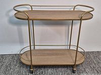 Full view of Martha Stewart Caleb bar cart showing metal frame, two shelves, casters
