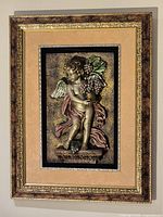 Framed relief wall plaque hanging on wall