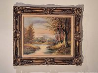 Framed oil on canvas landscape painting hanging on wall