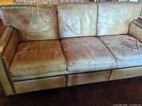 Full front view of sofa showing three cushions and nailhead trim