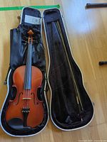 Violin, bow and open shaped case overview