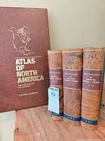 Front view of atlas slipcase and three dictionary volumes