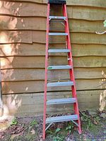 Full view of red fiberglass ladder showing all aluminum steps