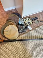 Group shot of all items including hats, Optex player, Maxell tapes, magnifier, glasses, walking stick
