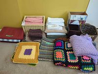 Entire lot overview showing towels, afghans, rugs, baskets and organizer