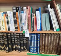Wide shot of bookshelf showing multiple encyclopaedia sets and assorted reference/gardening titles