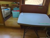 Mirror beside folding table showing materials and colors