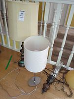 Two table lamps and chandelier parts shown together