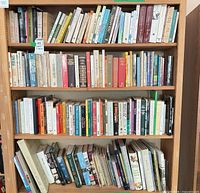 Full bookshelf view showing three shelves filled with assorted books