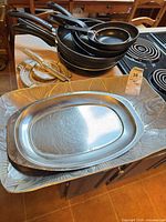Group shot of nested frying pans, tortilla press, trays