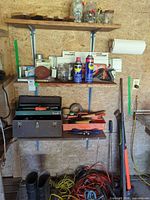 Full view of shelves, toolbox, WD-40 cans, hand tools, boots and cords