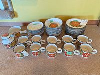 Overall lot showing plates, bowls, mugs, sugar bowl, creamer