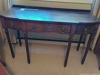 Front view of mahogany console table showing overall design, drawers and legs