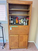 Full view of oak veneer bookcase cabinet with shelves, drop-front, and lower doors
