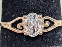 Top view of ring showing oval lab diamond and scroll shoulders
