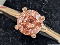 Front view of ring showing pink lab diamond in four-prong setting
