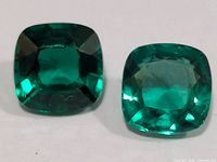 Close-up of both emerald gemstones showing color and cut