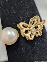Close view of pearl and butterfly accent on ring