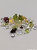 Pile of assorted loose gemstones on white background