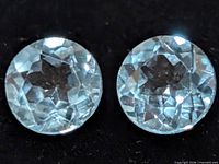 Close-up of two round blue topaz stones showing facets and clarity