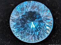Close-up of round faceted blue topaz gemstone