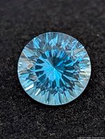 Round blue topaz close-up showing facets and color