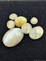 six cat's eye cabochon gemstones on black background