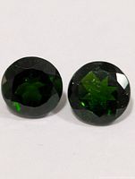 front view of two round chrome diopside gemstones
