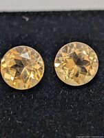 Close-up of two round faceted citrines showing color and cut